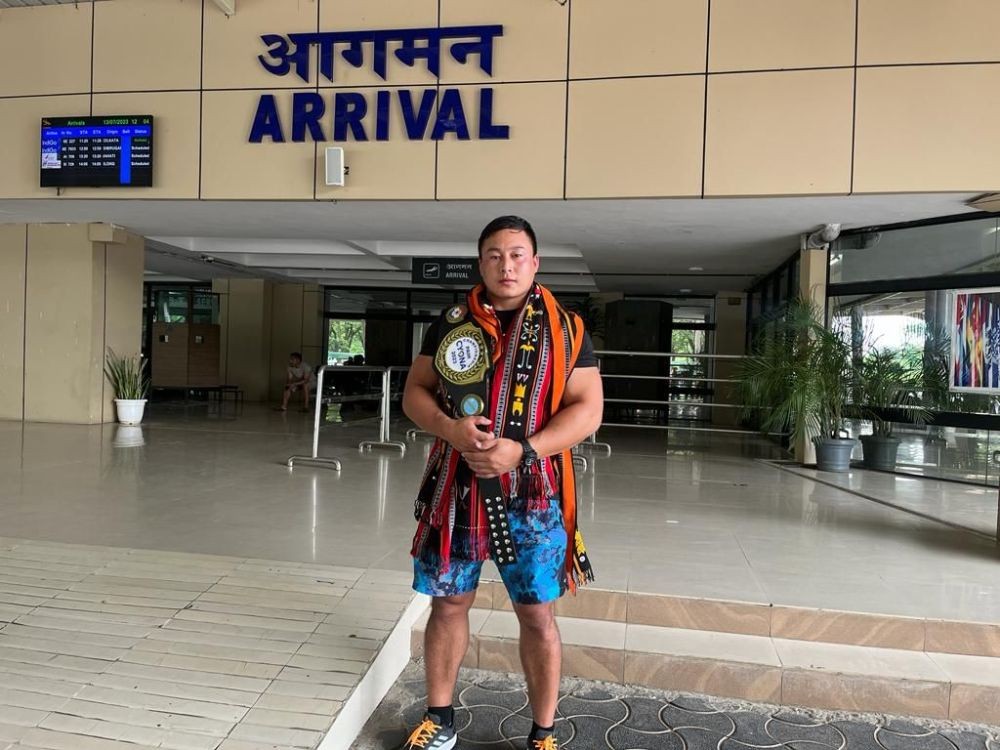 Reigning Naga wrestling champion, Venuzo Dawhuo posing for a photo with the Chin Wrestling Championship Title belt, at Dimapur airport on July 13. (Morung Photo)
